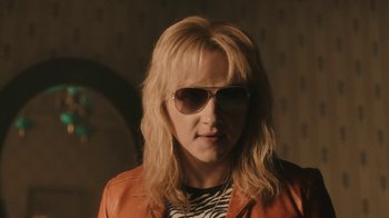 Movie still from “Bohemian Rhapsody” (2018), directed by Bryan Singer – A woman wearing sunglasses and a leather jacket; Close Up shot, Over the shoulder angle