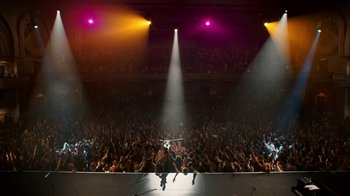 Movie still from “Bohemian Rhapsody” (2018), directed by Bryan Singer – A crowd of people in a stadium with lights on; Extreme Wide shot, High angle