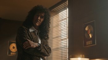 Movie still from “Bohemian Rhapsody” (2018), directed by Bryan Singer – A person with long hair and a leopard print jacket; Medium shot, Over the shoulder angle