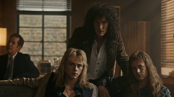 Movie still from “Bohemian Rhapsody” (2018), directed by Bryan Singer – A man and a woman sitting next to each other in front of a window; Medium shot, Low angle