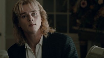 Movie still from “Bohemian Rhapsody” (2018), directed by Bryan Singer – A man with long blonde hair wearing a black jacket; Close Up shot, Low angle