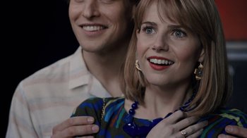 Movie still from “Bohemian Rhapsody” (2018), directed by Bryan Singer – A man and a woman smiling for the camera; Close Up shot, Over the shoulder angle