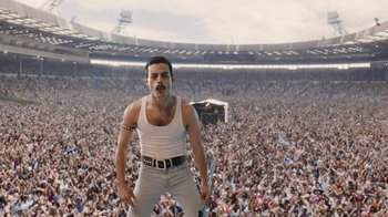 Movie still from “Bohemian Rhapsody” (2018), directed by Bryan Singer – A man standing in front of a crowd of people; Extreme Wide shot, Low angle