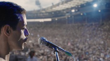 Movie still from “Bohemian Rhapsody” (2018), directed by Bryan Singer – A microphone in front of an audience in a stadium; Close Up shot, Low angle