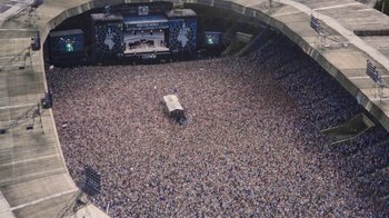 Movie still from “Bohemian Rhapsody” (2018), directed by Bryan Singer – An aerial view of a crowd of people in a stadium; Extreme Wide shot, High angle