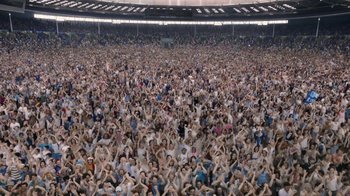 Movie still from “Bohemian Rhapsody” (2018), directed by Bryan Singer – A large crowd of people sitting in a stadium; Extreme Wide shot, High angle