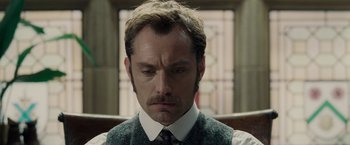 Movie still from “Sherlock Holmes: A Game of Shadows” (2011), directed by Guy Ritchie – A person wearing a suit and tie; Close Up shot, Low angle