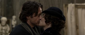 Movie still from “Sherlock Holmes: A Game of Shadows” (2011), directed by Guy Ritchie – A man and a woman kissing each other in front of a building; Close Up shot, Over the shoulder angle