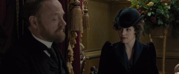 Movie still from “Sherlock Holmes: A Game of Shadows” (2011), directed by Guy Ritchie – A man and a woman are sitting next to each other; Medium shot, Over the shoulder angle