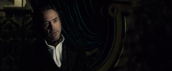 Movie still from “Sherlock Holmes: A Game of Shadows” (2011), directed by Guy Ritchie – A person wearing a suit and tie; Close Up shot, Over the shoulder angle