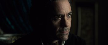 Movie still from “Sherlock Holmes: A Game of Shadows” (2011), directed by Guy Ritchie – A person wearing a suit and tie; Close Up shot, Over the shoulder angle