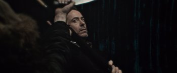 Movie still from “Sherlock Holmes: A Game of Shadows” (2011), directed by Guy Ritchie – A bald man is holding something in his hand; Close Up shot, Over the shoulder angle