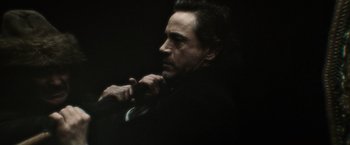 Movie still from “Sherlock Holmes: A Game of Shadows” (2011), directed by Guy Ritchie – A person with a suit on; Close Up shot, Over the shoulder angle