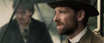 Movie still from “Sherlock Holmes: A Game of Shadows” (2011), directed by Guy Ritchie – A person wearing a hat; Close Up shot, Over the shoulder angle