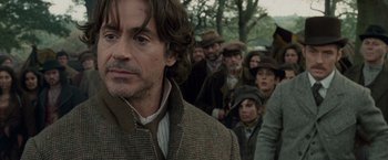 Movie still from “Sherlock Holmes: A Game of Shadows” (2011), directed by Guy Ritchie – A group of people are standing in a line; Close Up shot, Over the shoulder angle