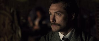 Movie still from “Sherlock Holmes: A Game of Shadows” (2011), directed by Guy Ritchie – A person wearing a suit and tie; Close Up shot, Low angle