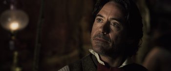 Movie still from “Sherlock Holmes: A Game of Shadows” (2011), directed by Guy Ritchie – A person wearing a vest and a bow tie; Close Up shot, Over the shoulder angle