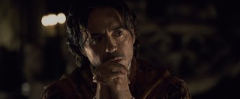 Movie still from “Sherlock Holmes: A Game of Shadows” (2011), directed by Guy Ritchie – A person with his hands clasped together; Close Up shot, Over the shoulder angle