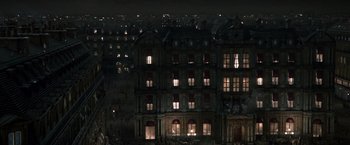 Movie still from “Sherlock Holmes: A Game of Shadows” (2011), directed by Guy Ritchie – A building with many windows lit up at night; Extreme Wide shot, High angle