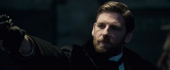 Movie still from “Sherlock Holmes: A Game of Shadows” (2011), directed by Guy Ritchie – A person wearing a suit and tie; Close Up shot, Over the shoulder angle