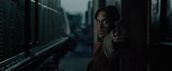 Movie still from “Sherlock Holmes: A Game of Shadows” (2011), directed by Guy Ritchie – A man leaning on a wall holding a gun; Close Up shot, Over the shoulder angle