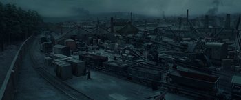 Movie still from “Sherlock Holmes: A Game of Shadows” (2011), directed by Guy Ritchie – An old train yard with many trains parked on the tracks; Extreme Wide shot, High angle