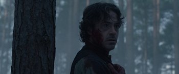 Movie still from “Sherlock Holmes: A Game of Shadows” (2011), directed by Guy Ritchie – A person with blood on his face; Close Up shot, Over the shoulder angle