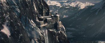 Movie still from “Sherlock Holmes: A Game of Shadows” (2011), directed by Guy Ritchie – An aerial view of a castle on top of a mountain; Extreme Wide shot, High angle