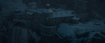 Movie still from “Sherlock Holmes: A Game of Shadows” (2011), directed by Guy Ritchie – An aerial view of a castle with snow on the roof; Extreme Wide shot, High angle
