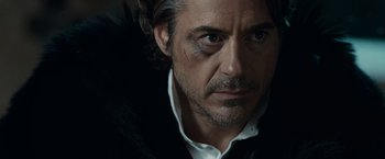 Movie still from “Sherlock Holmes: A Game of Shadows” (2011), directed by Guy Ritchie – A person wearing a shirt and jacket; Close Up shot, Over the shoulder angle