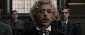 Movie still from “Sherlock Holmes: A Game of Shadows” (2011), directed by Guy Ritchie – A person wearing a suit and tie; Close Up shot, Low angle