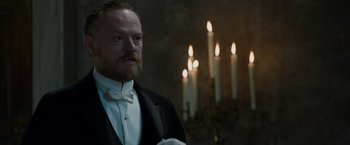 Movie still from “Sherlock Holmes: A Game of Shadows” (2011), directed by Guy Ritchie – A man in a tuxedo standing in front of candles in a room; Close Up shot, Low angle
