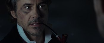 Movie still from “Sherlock Holmes: A Game of Shadows” (2011), directed by Guy Ritchie – A person with a pipe in his mouth; Close Up shot, High angle