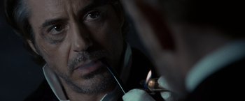 Movie still from “Sherlock Holmes: A Game of Shadows” (2011), directed by Guy Ritchie – A person holding a pair of pliers; Extreme Close Up shot, Over the shoulder angle