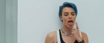 A woman with blue hair sticking out her tongue