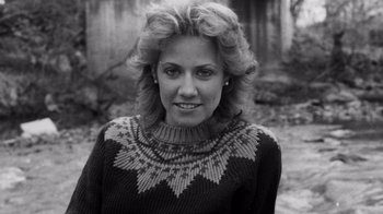 Movie still from “Sheryl” (2022), directed by Amy Scott – Black and white photograph of a woman wearing a sweater; Close Up shot, High angle