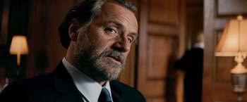 Movie still from “Shooter” (2007), directed by Antoine Fuqua – An older man in a suit and a tie; Close Up shot, Low angle