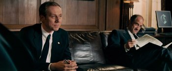 Movie still from “Shooter” (2007), directed by Antoine Fuqua – A man sitting on top of a couch in a living room; Medium shot, Over the shoulder angle