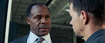 Movie still from “Shooter” (2007), directed by Antoine Fuqua – A man wearing a suit and tie talking to another man; Close Up shot, Over the shoulder angle
