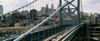 Movie still from “Shooter” (2007), directed by Antoine Fuqua – A view of a bridge with a city in the background; Extreme Wide shot, High angle