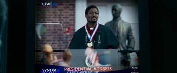 Movie still from “Shooter” (2007), directed by Antoine Fuqua – A man is giving a speech in front of a crowd; Close Up shot, Low angle