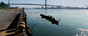 Movie still from “Shooter” (2007), directed by Antoine Fuqua – A car is flying through the air over a body of water; Extreme Wide shot, High angle