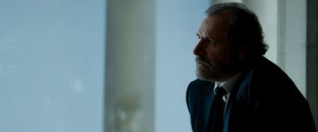 Movie still from “Shooter” (2007), directed by Antoine Fuqua – A person wearing a suit and tie; Close Up shot, Low angle