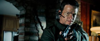 Movie still from “Shooter” (2007), directed by Antoine Fuqua – A man in a black jacket holding a gun in his hand; Close Up shot, Low angle