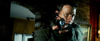 Movie still from “Shooter” (2007), directed by Antoine Fuqua – A man holding a gun while wearing a headset; Close Up shot, Over the shoulder angle