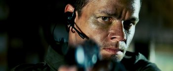 Movie still from “Shooter” (2007), directed by Antoine Fuqua – A person wearing a headset and holding a gun; Close Up shot, Low angle