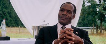 Movie still from “Shooter” (2007), directed by Antoine Fuqua – A man in a suit and tie clapping his hands; Close Up shot, Low angle