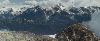 Movie still from “Shooter” (2007), directed by Antoine Fuqua – An airplane is flying in the air over a mountain range; Extreme Wide shot, High angle