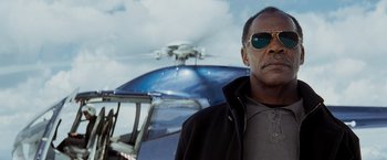 Movie still from “Shooter” (2007), directed by Antoine Fuqua – A man wearing sunglasses standing in front of a helicopter; Close Up shot, Low angle