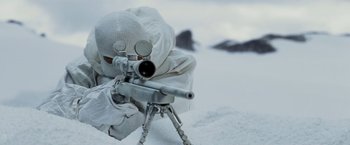 Movie still from “Shooter” (2007), directed by Antoine Fuqua – A person in a white suit is aiming a sniper rifle; Medium shot, High angle